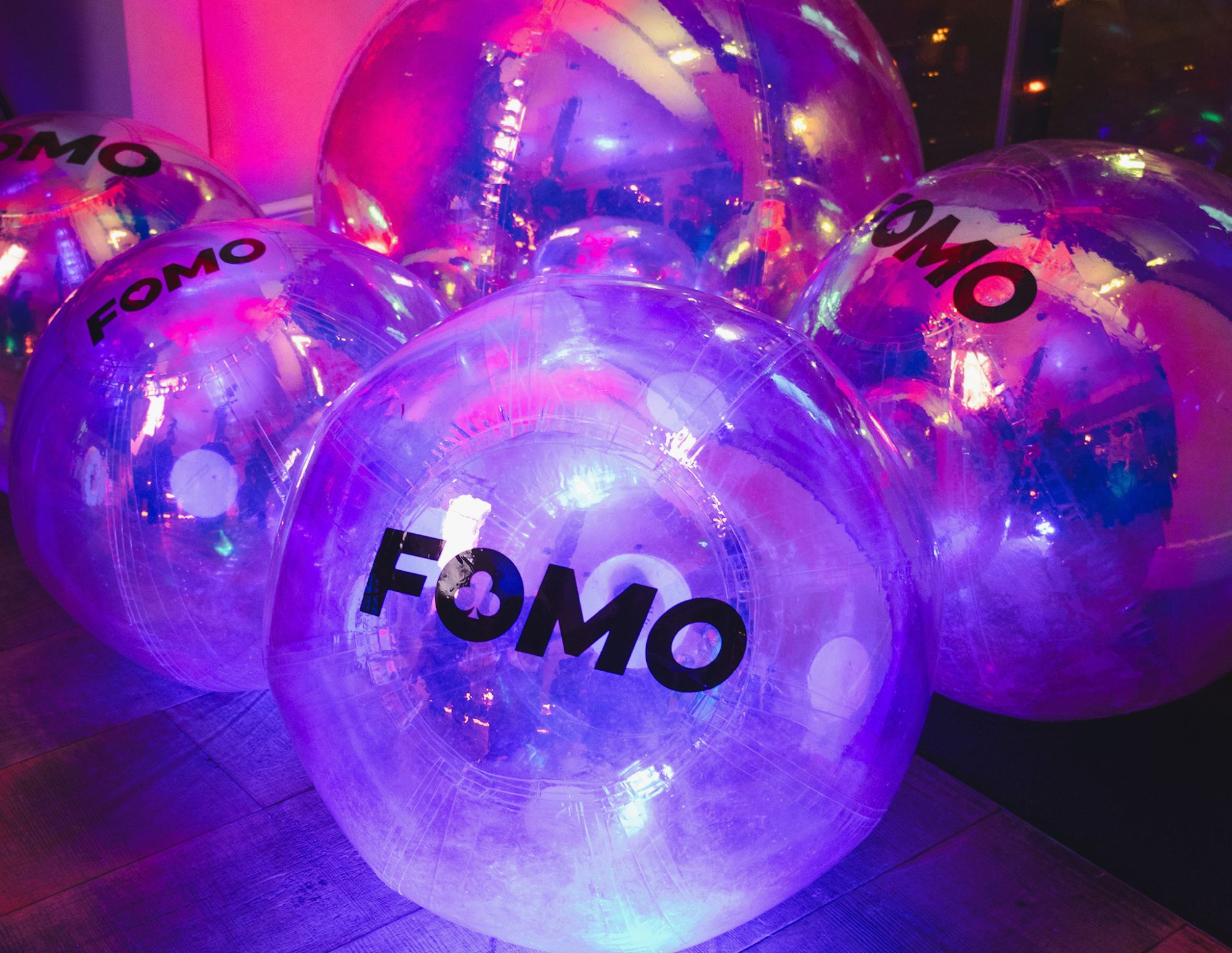 Oversized branded balloons lit from within on the party floor