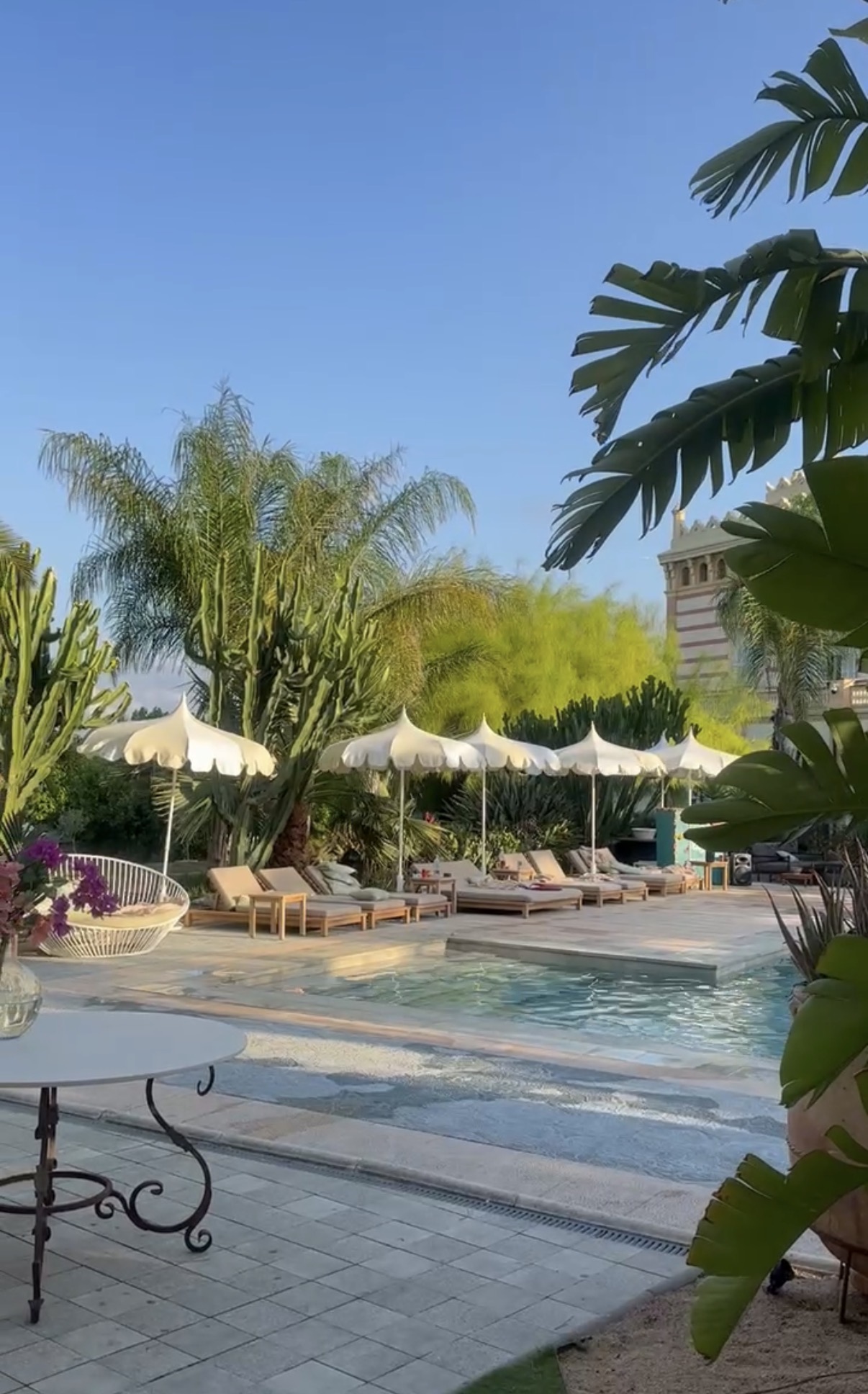 Loungers and white parasols set out around the villa pool