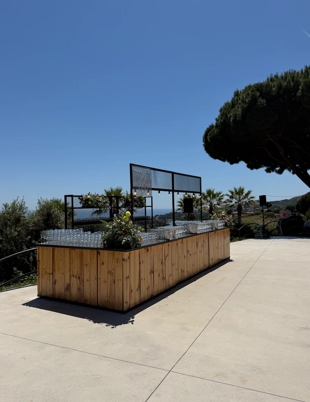 The long wooden bar on the terrace, set up and overlooking the coast
