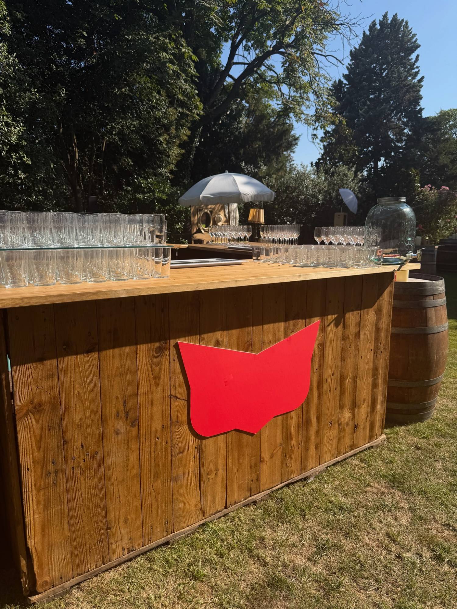The garden bar in wood with the brand mark on the front and glassware set out